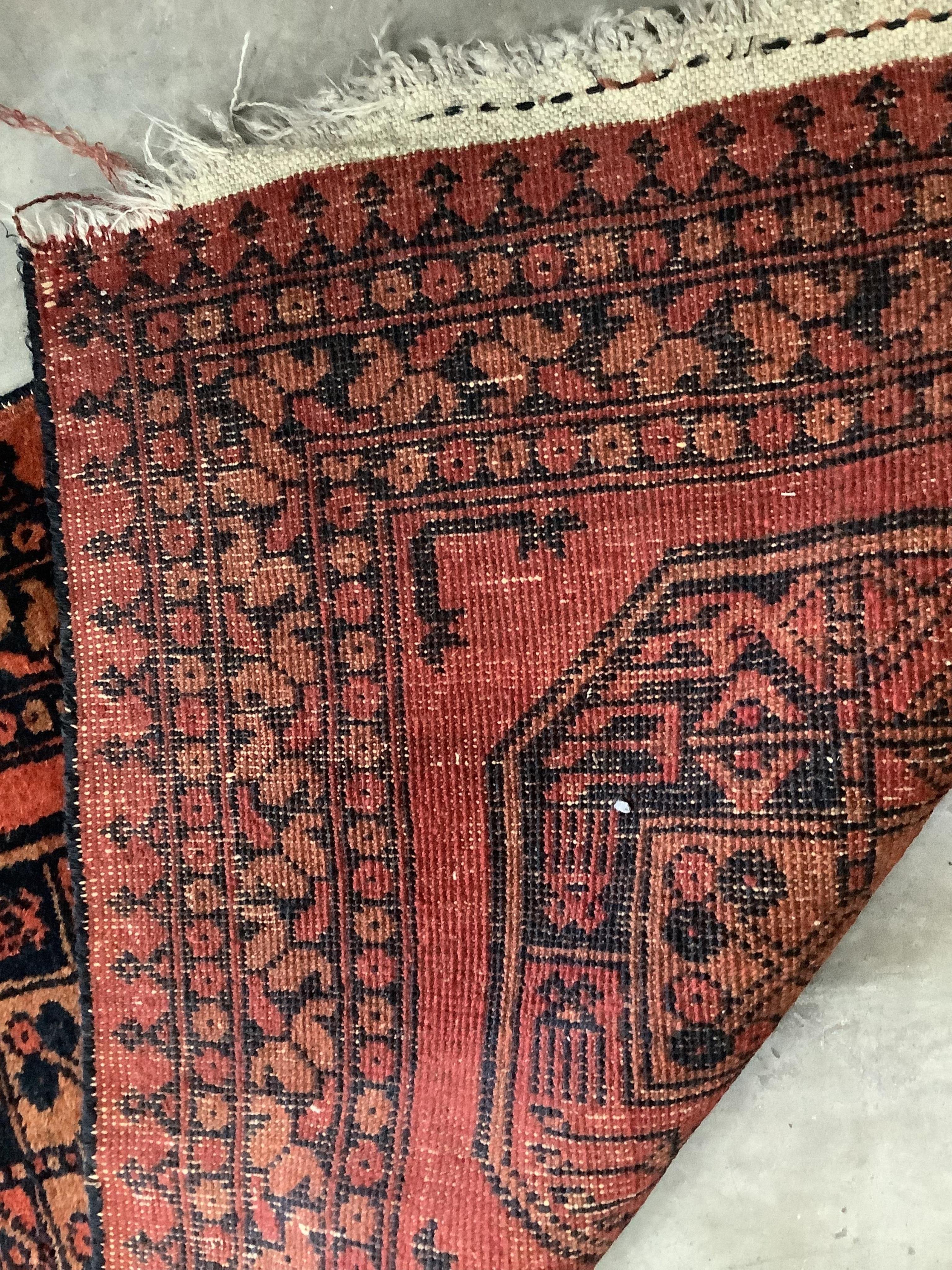 A pair of Afghan red ground rugs, each 144 x 75cm. Condition - fair